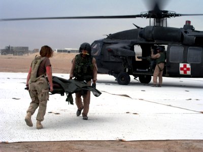 US Navy 030412-N-0728B-001 Hospital Corpsman 2nd Class Sara Beishir and a crewmember of an Army UH-60 Black Hawk helicopter transfers one of the more than 500 patients seen by Fleet Hospital Three (FH-3)