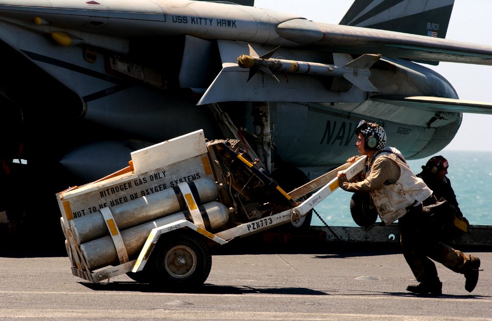 US Navy 030328-N-1810F-005 A Sailor assigned to Carrier Air Wing Five (CVW-5) liquid oxygen (LOX) division transports a nitrogen cart to a Carrier Air Wing Five (CVW-5) aircraft on the flight deck aboard the aircraft carrier US