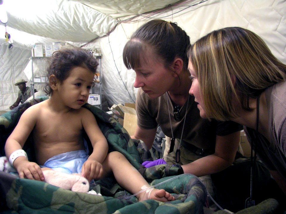 US Navy 030410-N-0728B-001 Hospital Corpsman 1st Class Jody Stenquist from Pontiac, Mich., and Hospital Corpsman 2nd Class Sara Beishir from St. Louis, Mo help a young patient