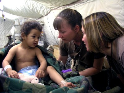 US Navy 030410-N-0728B-001 Hospital Corpsman 1st Class Jody Stenquist from Pontiac, Mich., and Hospital Corpsman 2nd Class Sara Beishir from St. Louis, Mo help a young patient