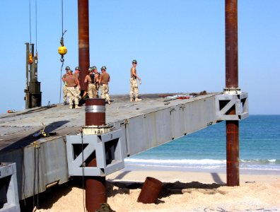 US Navy 030402-N-1050K-046 U.S. Navy Seabees attached to Amphibious Construction Battalions One and Two (ACB-1, ACB-2) discuss their next move in the building of the Elevated Causeway System (ELCAS)-modular structure at