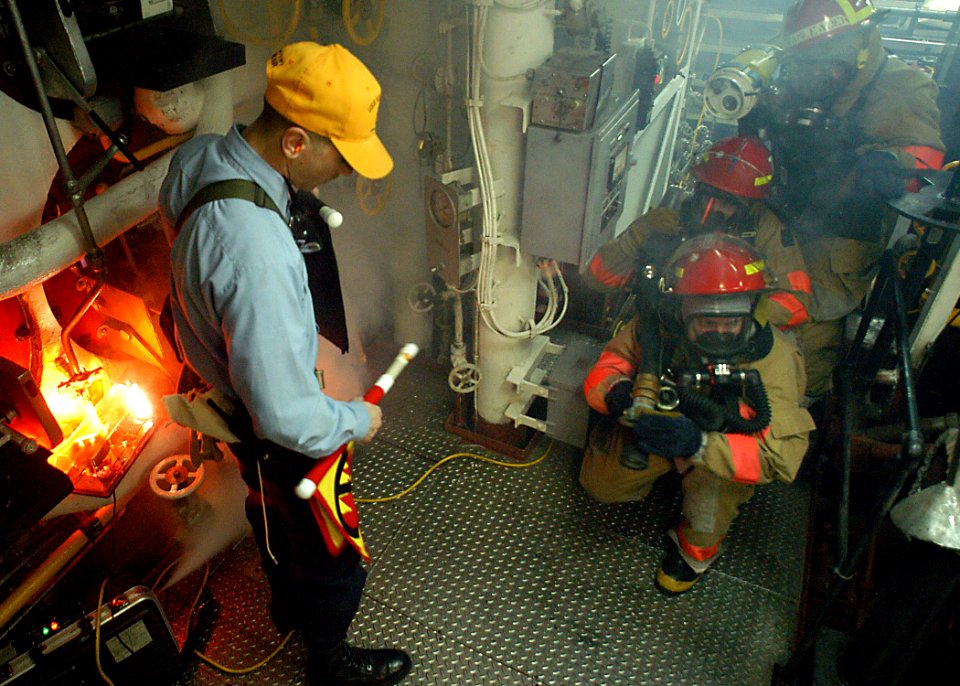 US Navy 030314-N-4048T-092 Hull Maintenance Technician 1st Class John Gombar, a member of the ship's Damage Control Training Team, conducts a main engineering space fire drill