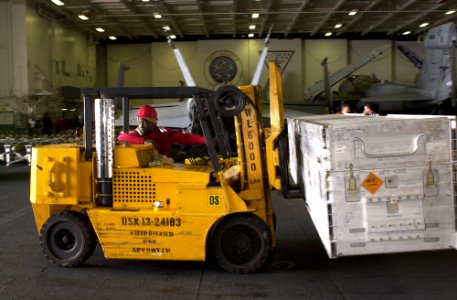 US Navy 030402-N-6536T-001 Aviation Ordnanceman 3rd Class Odell Mason from Richmond, Calif., transfers ordnance containers to Elevator Three in the ship's hanger bay