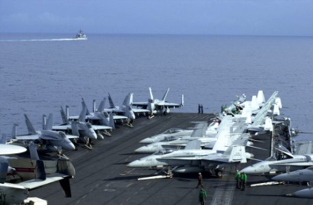 US Navy 030327-N-2143T-002 Aircraft from Carrier Air Wing Eleven (CVW-11) are chocked and chained to the forward catapults aboard USS Nimitz (CVN 68) while the guided missile cruiser USS Princeton (CG 59) sails by