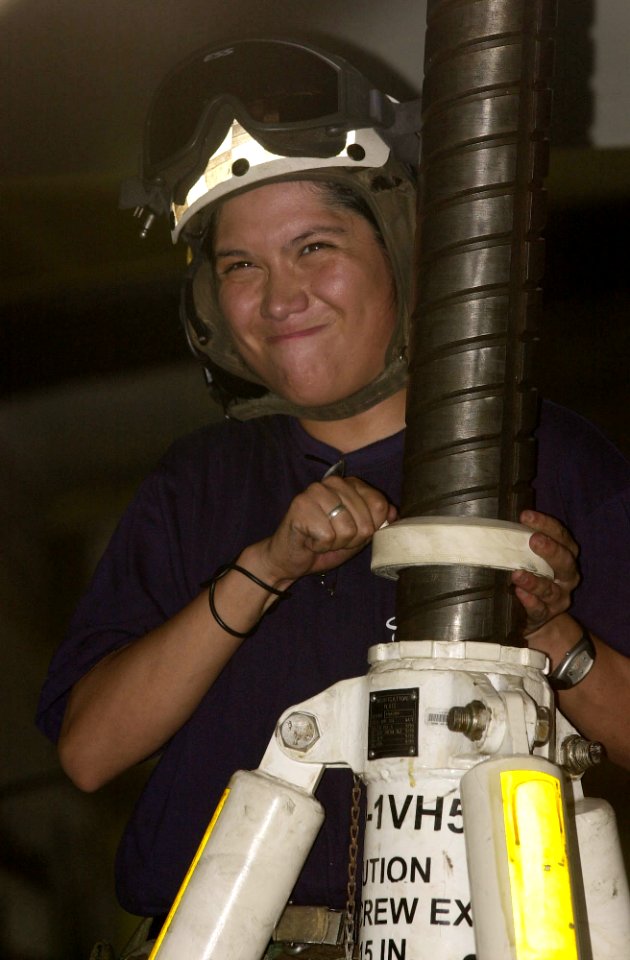US Navy 030413-N-9319H-002 Aviation Maintenance Administrationman Cathy Garcia participates in the elevating of an E-2C Hawkeye