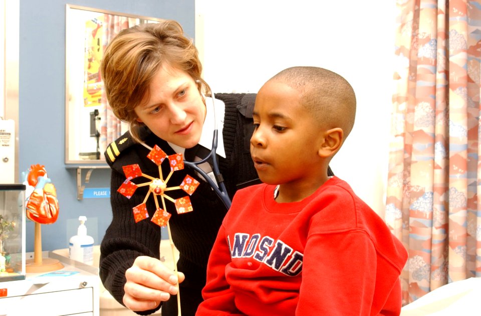 US Navy 030328-N-0000W-001 Lt. Marjorie Nasin uses a Japanese toy to help a young patient blow air as she listens to his breathing