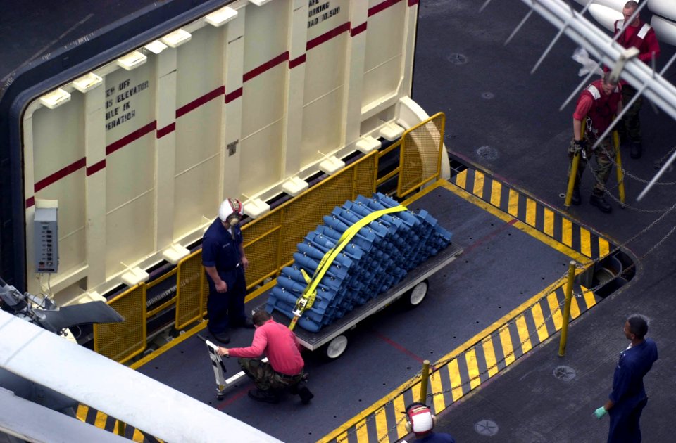 US Navy 030401-N-2385R-004 Sailors transfer MK-76 practice bombs on the weapons elevator from the ship's flight deck to the hangar bay aboard USS Nimitz (CVN 68)