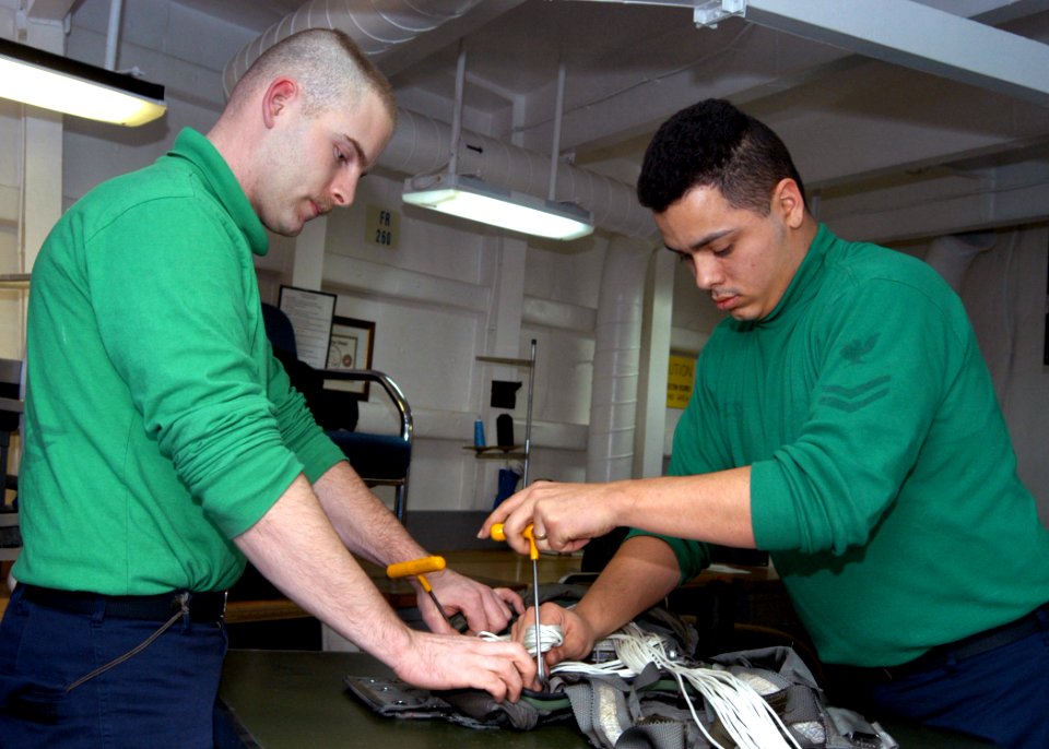 US Navy 030402-N-5786V-508 Aircrew Survival Equipmentman Airman Jeremiah Cranford and Aircrew Survival Equipmentman 2nd Class James Hess assigned to USS Theodore Roosevelt's (CVN 71) Aviation Intermediate Maintenance Department