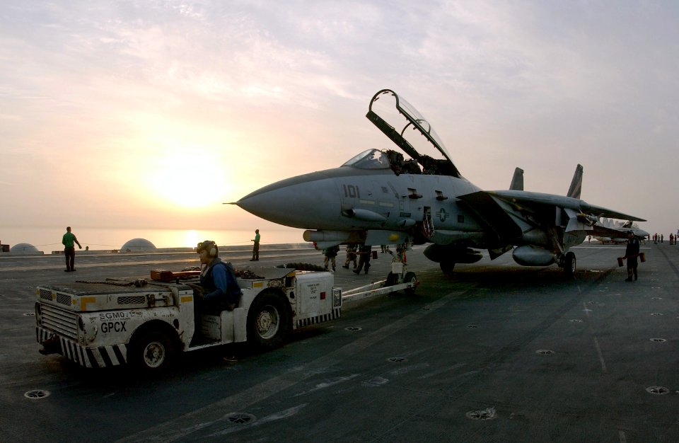 US Navy 030406-N-1810F-012 An F-14A Tomcat fighter aircraft is pulled into position on the flight deck by a tow tractor aboard USS Kitty Hawk (CV 63)