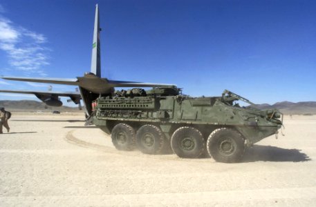 US Navy 030324-A-0000L-044 A Stryker interim armored vehicle speeds away after being offloaded from an Air Force C130 Hercules aircraft