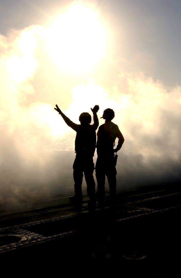 US Navy 030402-N-1810F-007 Aircraft Directors use hand-signals while engulfed with steam from one of the four steam-powered catapults on the flight deck aboard USS Kitty Hawk (CV 63)