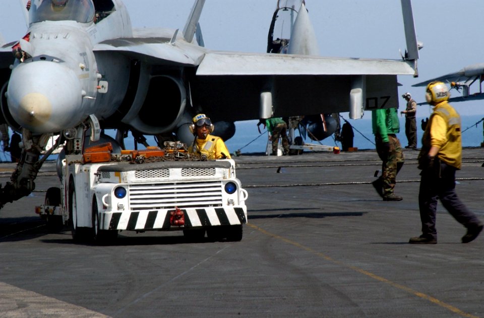 US Navy 030411-N-6895M-501 Flight deck crewmembers move an F-A-18 Hornet on the flight deck of USS Theodore Roosevelt (CVN 71)