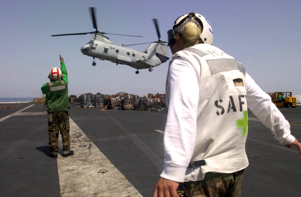US Navy 030415-N-8273J-006 Crewmembers recover a CH-46 Sea Knight on the flight deck aboard USS Nimitz (CVN 68) during a Vertical Replenishment (VERTREP) with the fast combat support ship USS Bridge (AOE 10)