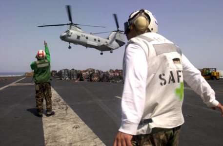 US Navy 030415-N-8273J-006 Crewmembers recover a CH-46 Sea Knight on the flight deck aboard USS Nimitz (CVN 68) during a Vertical Replenishment (VERTREP) with the fast combat support ship USS Bridge (AOE 10)