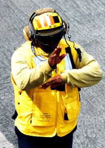 US Navy 080922-N-2183K-107 A flight deck crewman uses hand signals to communicate with other personnel on the flight deck