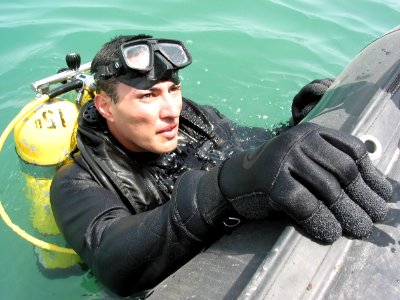 US Navy 030415-N-1050K-020 Construction Electrician Robert Soto surfaces to provide placement information to a range safety officer (RSO) after placing 65lbs of high explosives underwater during a recent joint debris clearing photo