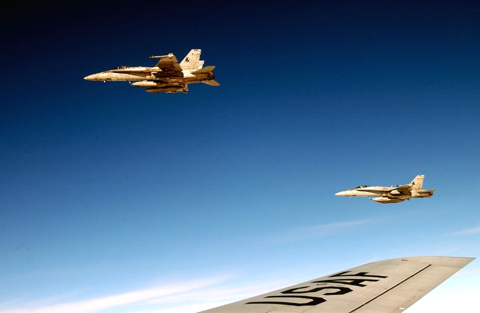 US Navy 030417-F-6809H-019 F-A-18 Hornets are ready to return to their mission after conducting refueling operations with a U.S. Air Force KC-135R Stratotanker