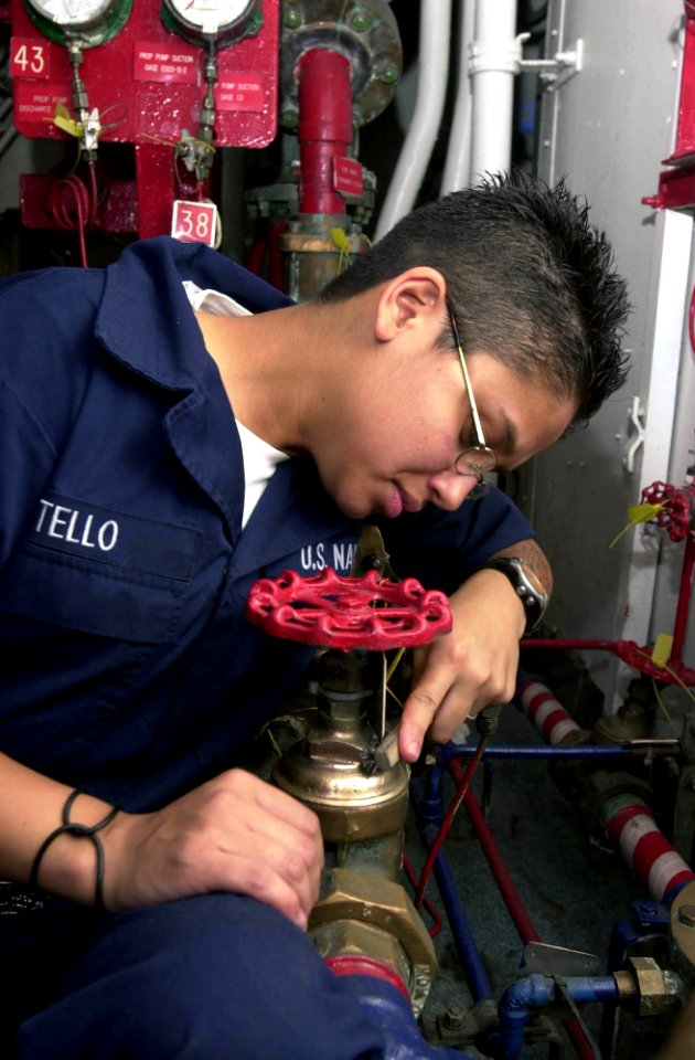US Navy 030506-N-1577S-002 Fireman Erica Tello performs preventive maintenance and corrosion control on a valve, on an Aqueous Film Forming Foam (AFFF) station to prevent corrosion on the valves