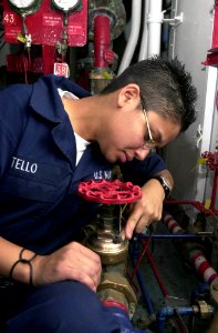 US Navy 030506-N-1577S-002 Fireman Erica Tello performs preventive maintenance and corrosion control on a valve, on an Aqueous Film Forming Foam (AFFF) station to prevent corrosion on the valves