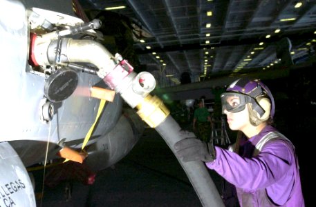 US Navy 030425-N-1577S-001 Airman Lorena Tiscareno from Mesa, Ariz., refuels an F-18