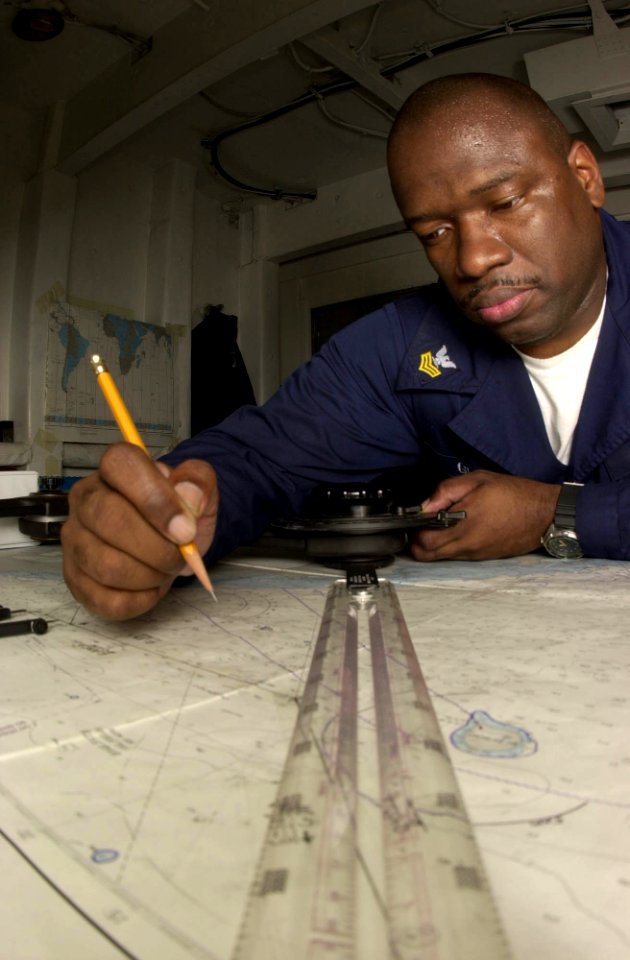 US Navy 030519-N-1577S-001 Quartermaster 1st Class Anthony Glover of Chicago Ill., checks the accuracy of a nautical map that is used to navigate USS Nimitz (CVN 68) photo