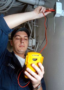 US Navy 030515-N-1512S-030 Electrician's Mate Fireman Travis O'Leary checks an outlet for power aboard the amphibious assault ship USS Kearsarge (LHD 3)