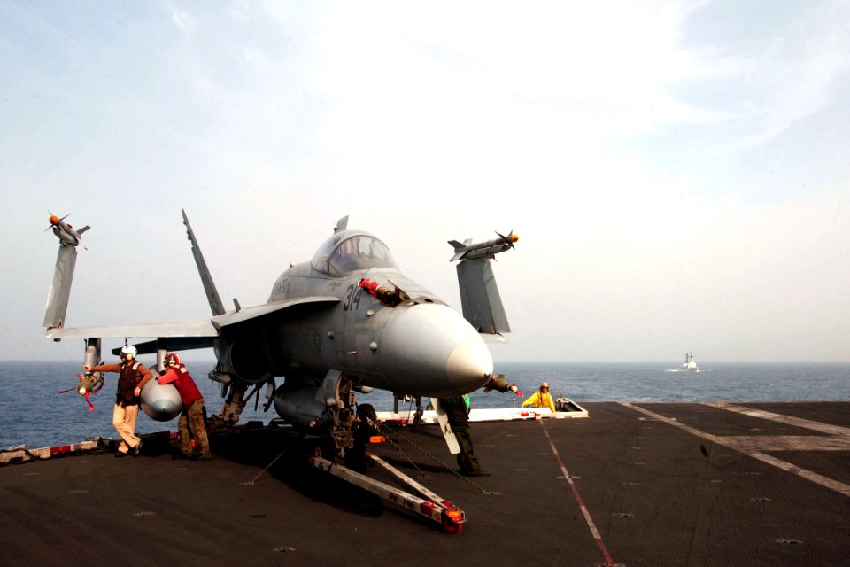 US Navy 030403-N-7781D-016 An F-A-18 Hornet sits on the fantail aboard USS Harry S. Truman (CVN 75) as the U.S. Coast Guard Cutter Dallas (WHEC-716)