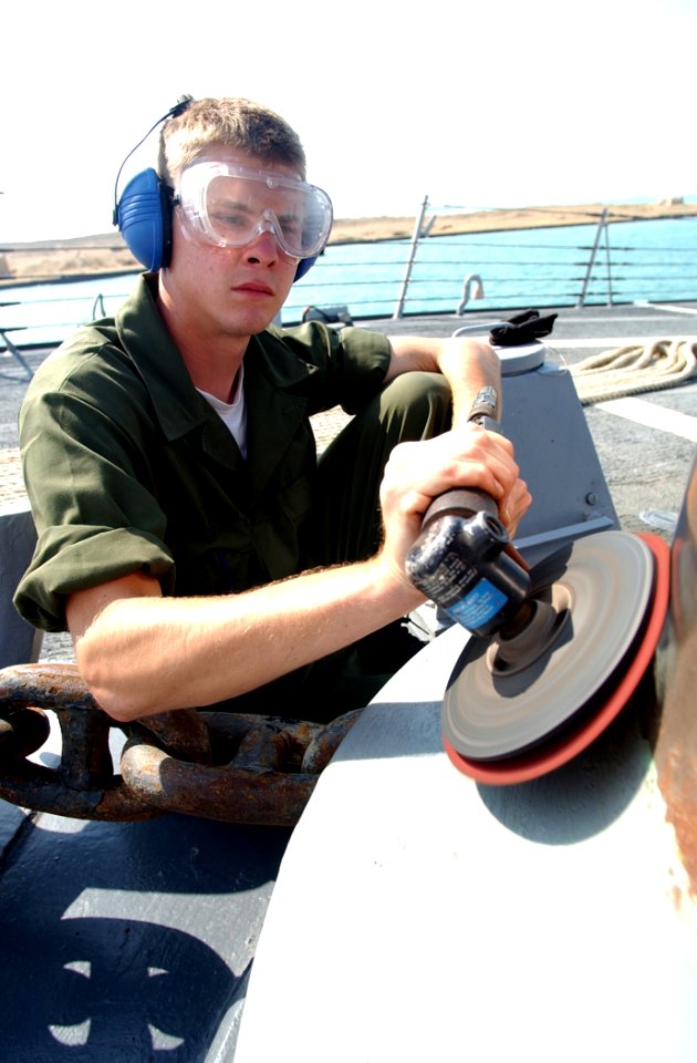 US Navy 030426-N-6141B-009 Seaman Nicholas Dalton from Corpus Christi, Texas, polishes one of the ship's capstans