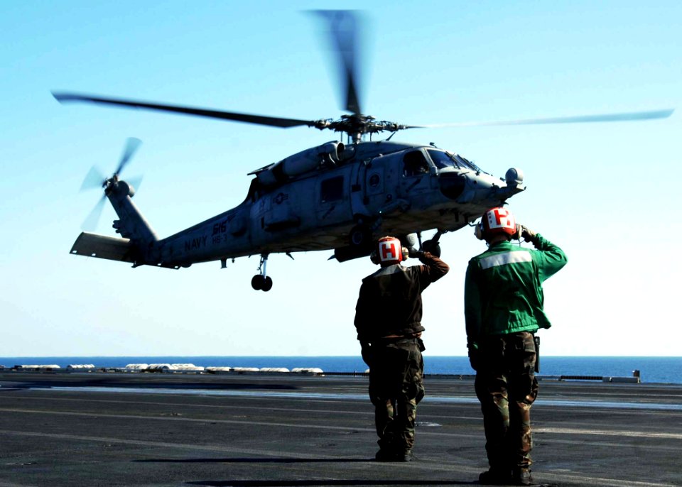 US Navy 081208-N-8822R-060 Sailors on the flight deck salute a pilot as an HH-60H Sea Hawk helicopter assigned to the