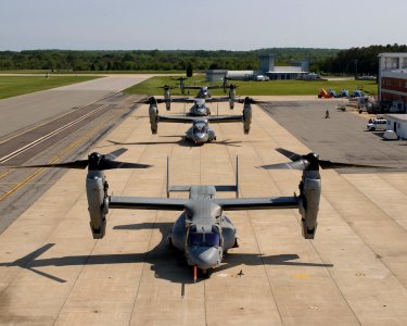US Navy 030601-N-0000X-001 Four V-22 Osprey aircraft sit along the flight line with rotors turning before recent test flights photo