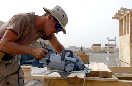 US Navy 030501-N-6077T-003 Builder Constructionman Patrick Dinottia from Binghamton, N.Y., pre-fabricates lumber to construct four hole latrines