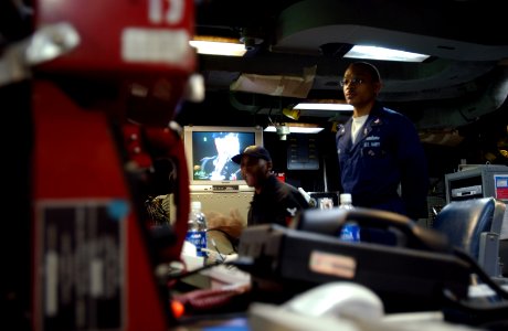US Navy 030422-F-5820C-005 An Operations Specialist 1st Class (left) conducts a briefing in the Tactical Flag Command Center aboard the amphibious command ship USS Blue Ridge (LCC-19)