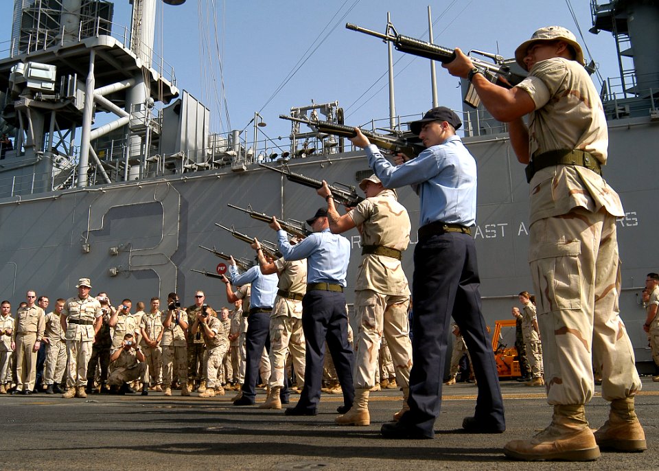 US Navy 030526-N-2819P-041 A U.S. Navy-Marine Corps firing detail provides a 21-gun salute on the flight deck aboard USS Kearsarge