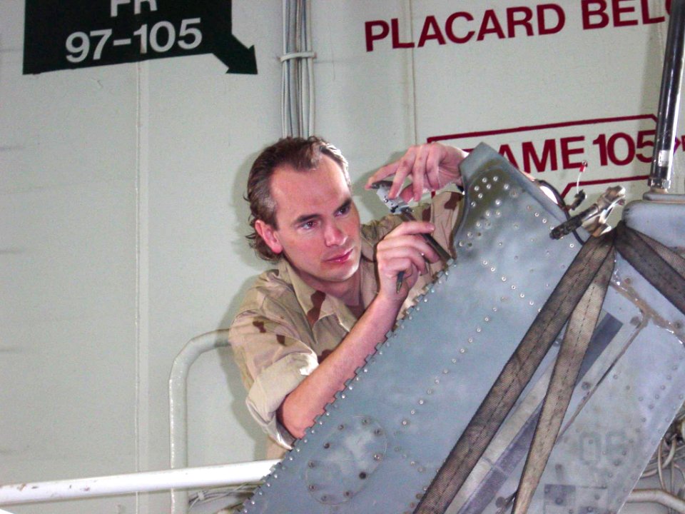 US Navy 030503-N-0000X-001 Tim Hoffman, an aerospace engineer from Naval Aviation Systems Command (NAVAIRSYSCOM) Depot North Island, Calif., evaluates damage to a UH-1 Huey