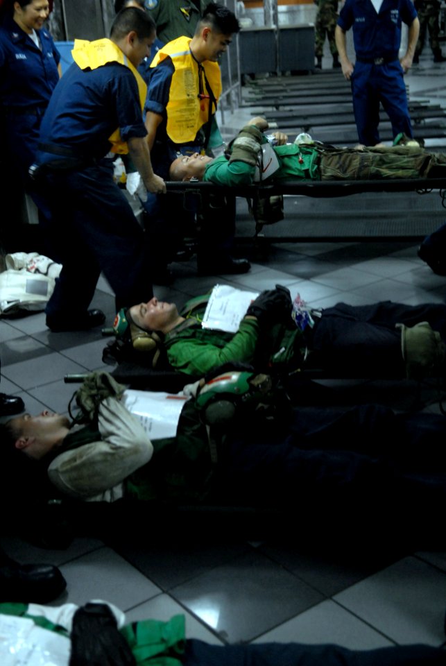 US Navy 081022-N-1635S-004 Stretcher-bearers lift a simulated personnel casualty during a mass casualty drill