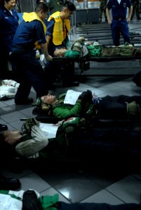 US Navy 081022-N-1635S-004 Stretcher-bearers lift a simulated personnel casualty during a mass casualty drill