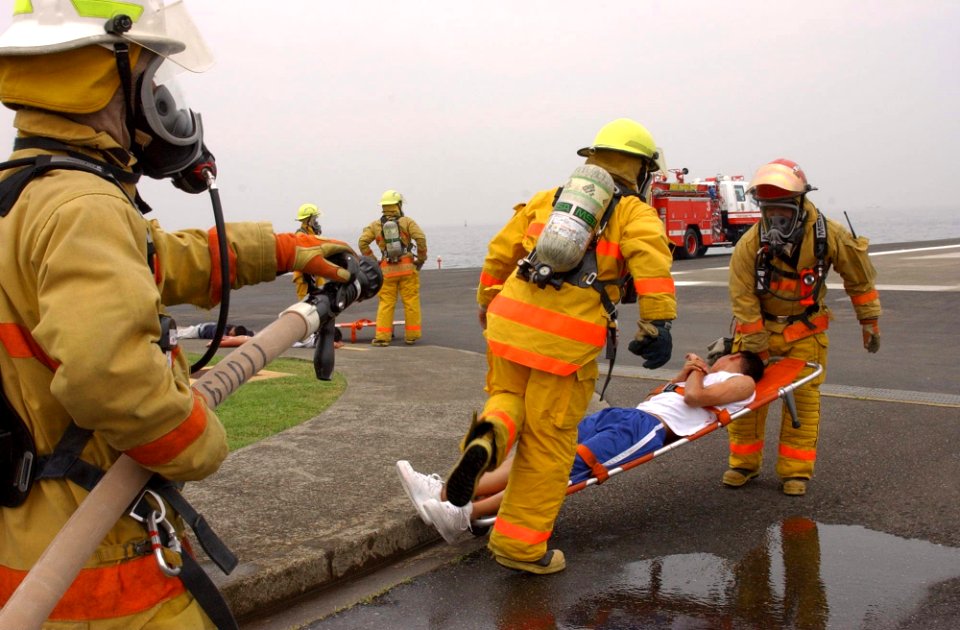 US Navy 030604-N-0000W-002 Firefighters from Commander, Naval Forces Japan Regional Fire Department are first on the scene, to assist simulated casualties during a helicopter crash training exercise