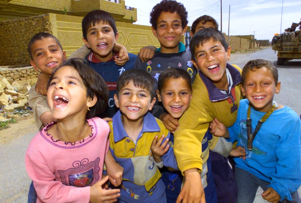 US Navy 030412-A-9330B-093 A group of Iraqi children pose for a photo while their parents receive humanitarian daily rations (HDR's) and water in the town of Ar Rutba