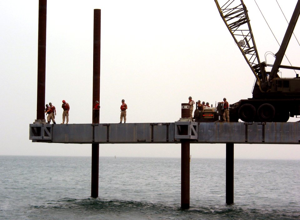 US Navy 030412-N-1050K-040 U.S. Navy Seabees attached to Amphibious Construction Battalions One and Two (ACB-1, ACB-2) prepare to place the next pile in the building of the Elevated Causeway System-Modular (ELCAS-M) structure