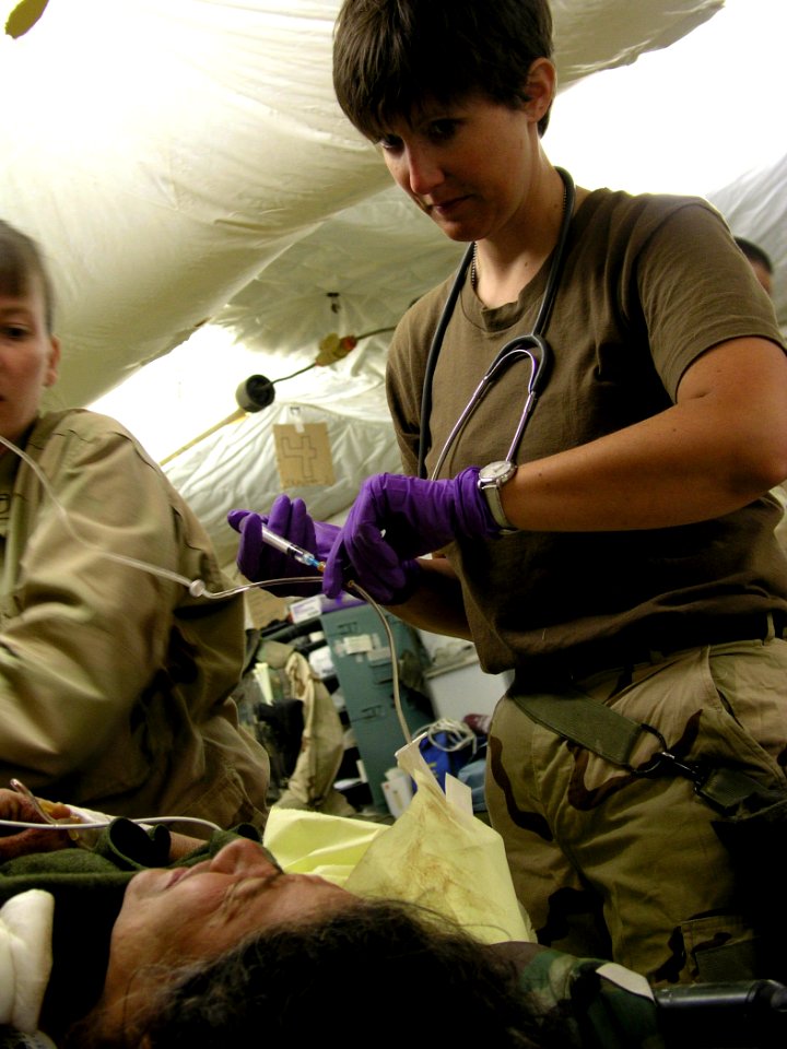 US Navy 030414-N-0728B-002 Ensign Jill Skeet from Williamsburg, Kan., administers pain medication to an unidentified Iraqi woman who arrived in Fleet Hospital Three's (FH-3) Casualty Receiving room with a gunshot wound