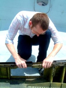 US Navy 030614-N-9999Z-001 Benjamin Walsh, a Naval Air Systems Command (NAVAIR) engineer with the Naval Air Pacific Repair Facility (NAPRA), evaluates damage to a P-3 Orion before preparing the Temporary Engineering Instruction