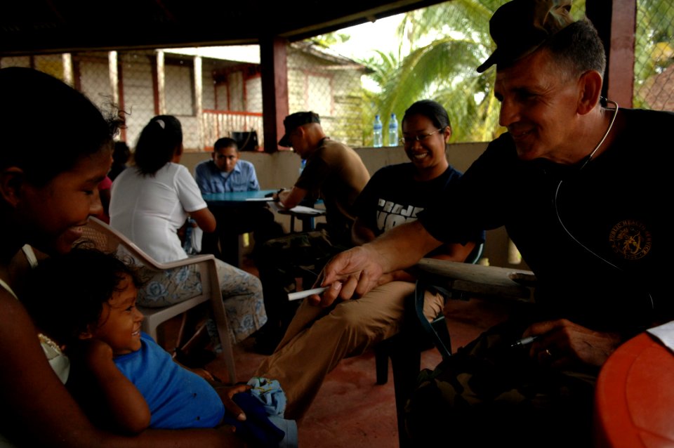 US Navy 080823-N-7544A-168 Lt. Cmdr. Paul Wickard examines a young boy photo