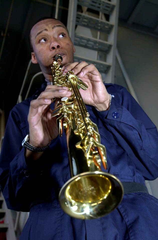 US Navy 030619-N-2143T-007 A sailor plays a Soprano Sax during a Jazz night out on the fantail hosted by First Class Petty Officer Association where they get a chance to smoke cigars and relax aboard USS Nimitz (CVN 68)
