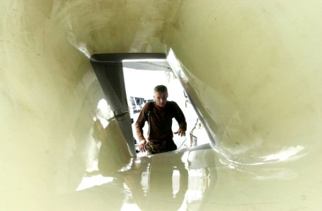 US Navy 030602-N-2143T-002 Airman Nathan Bucharon from Newark, Calif., prepares to jump into the intake of an F-A-18 Super Hornet
