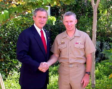 US Navy 030605-N-0000X-001 President George W. Bush congratulates Capt. Terence E. McKnight, Commanding Officer of the amphibious assault ship USS Kearsarge (LHD 3) for the support received from the officers and crew of the amp photo