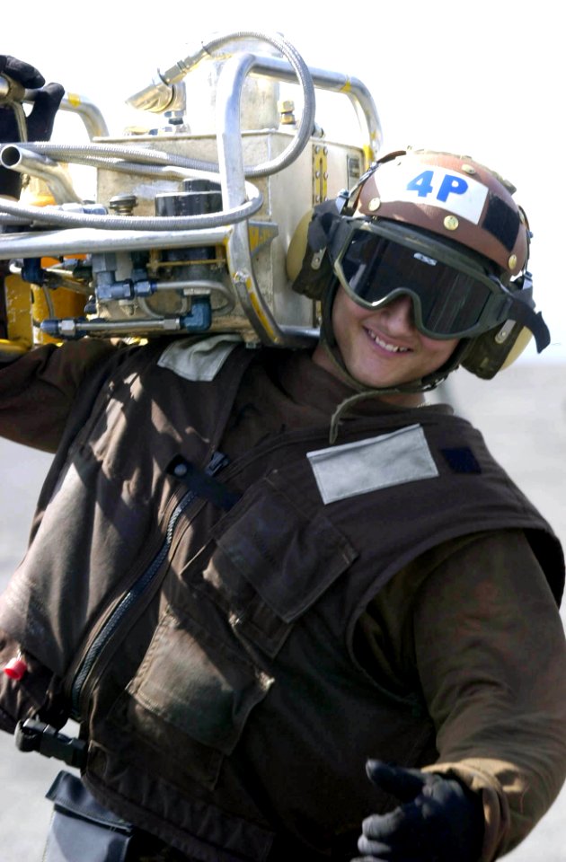 US Navy 030524-N-2385R-002 Airman Brian Whittlsey, of Las Vegas, Nev., carries a Pre-Oiling and Pressure Fill Tank (PON-6) to service an engine