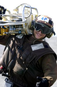 US Navy 030524-N-2385R-002 Airman Brian Whittlsey, of Las Vegas, Nev., carries a Pre-Oiling and Pressure Fill Tank (PON-6) to service an engine