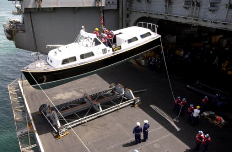 US Navy 030607-N-2143T-004 Sailors assigned to Deck Department aboard USS Nimitz (CVN 68) work together to lower Rear Admiral Samuel J. Locklear's, Commander Cruiser Destroyer Group Five, barge while visiting the Kingdom of Bah