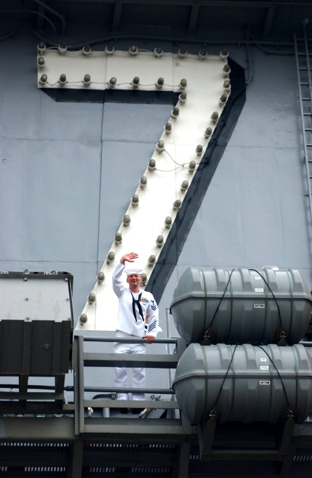 US Navy 030529-N-0696M-073 Hospital Corpsman 1st Class Kevin Martin waves to his wife from the flight deck aboard USS Theodore Roosevelt (CVN 71) during the aircraft carrier's homecoming