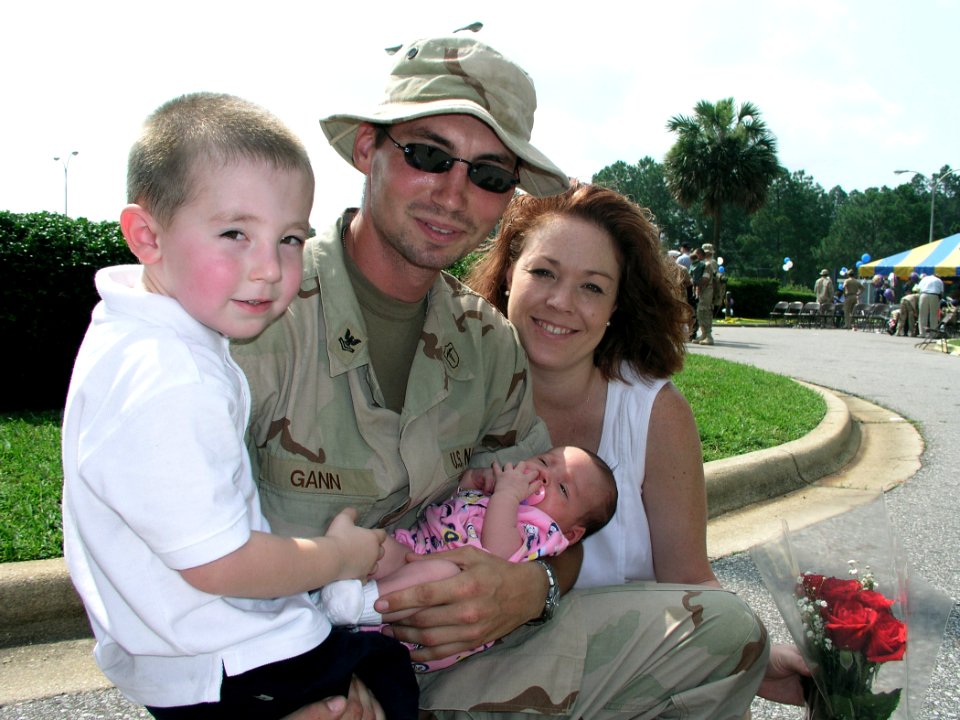 US Navy 030609-N-0728B-005 Hospital Corpsman 2nd Class Bradley Gann is reunited with his family and holds his one month daughter for the first time